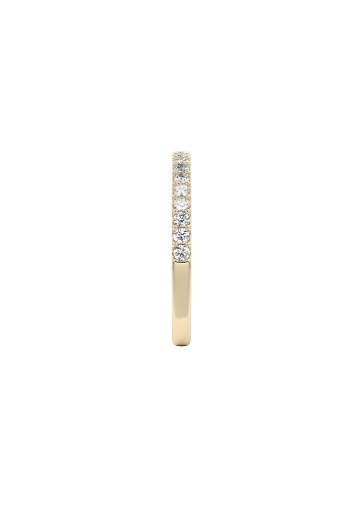 A slim yellow gold eternity ring featuring a row of round brilliant-cut diamonds set along the upper half, shown against a clean white background.