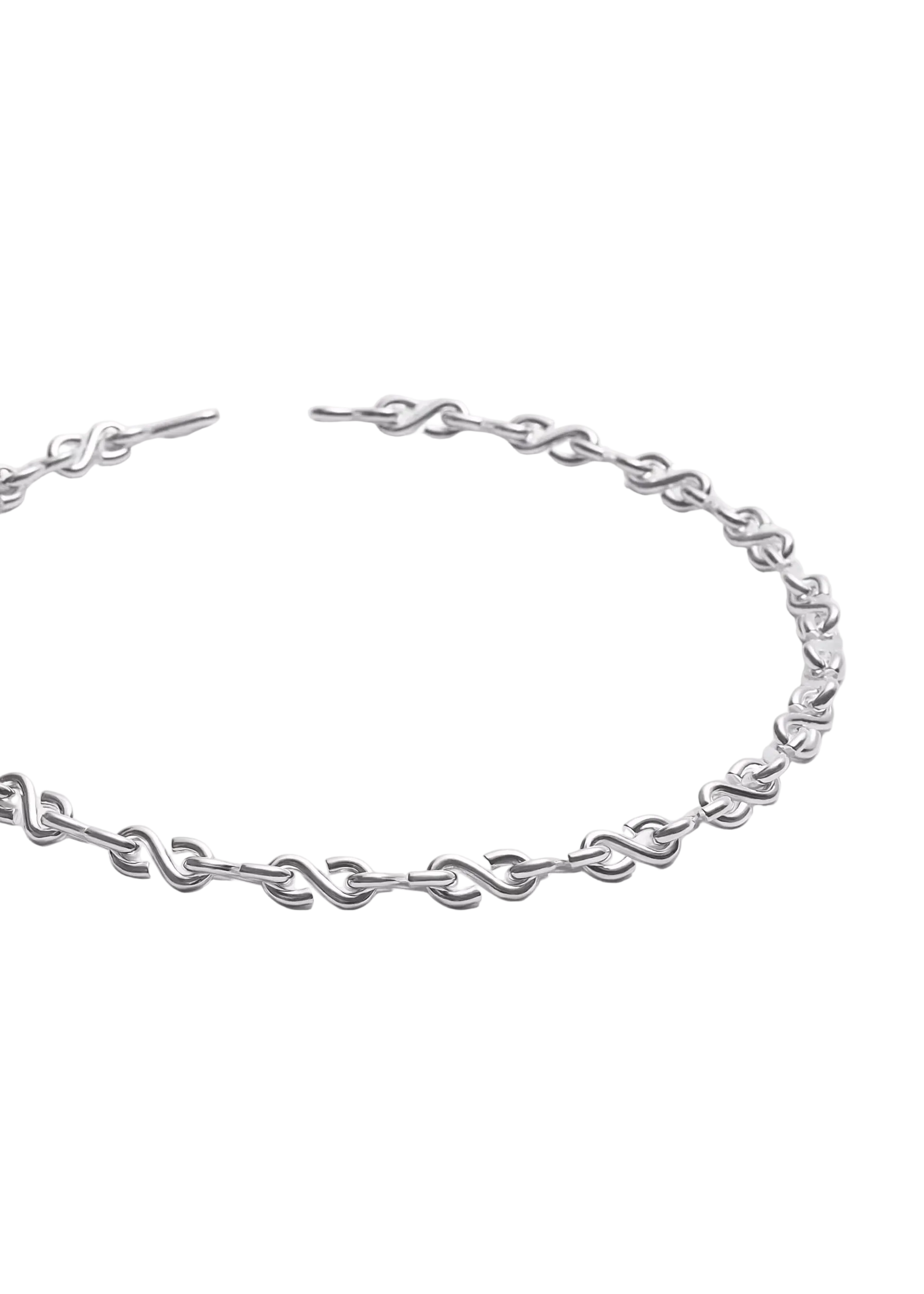 A silver-toned metal chain necklace with a unique interlocking link design, displayed on a clean, light gray background.