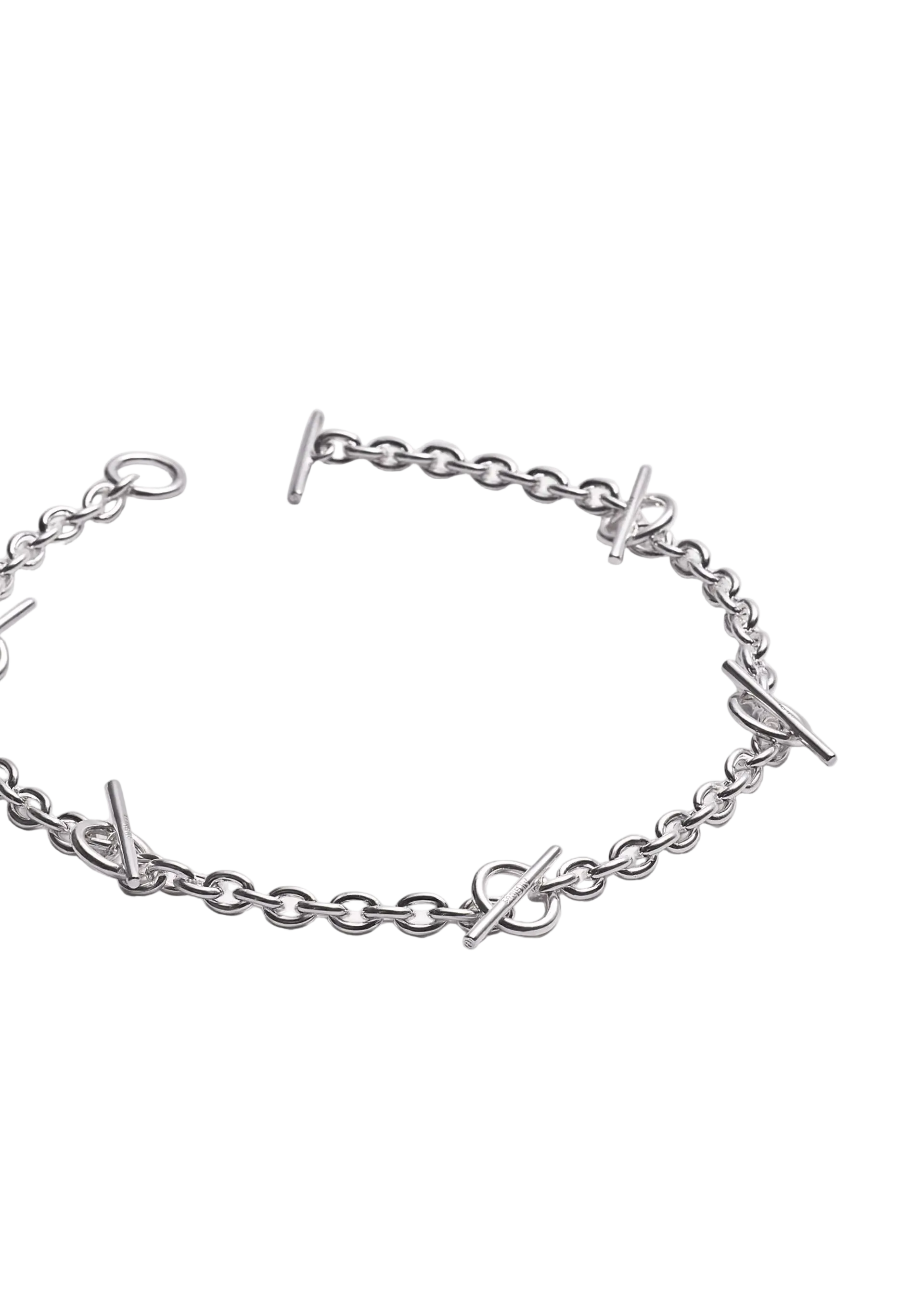 A silver chain bracelet featuring interlocking bar links and small stylized letter charms, displayed on a clean white background.