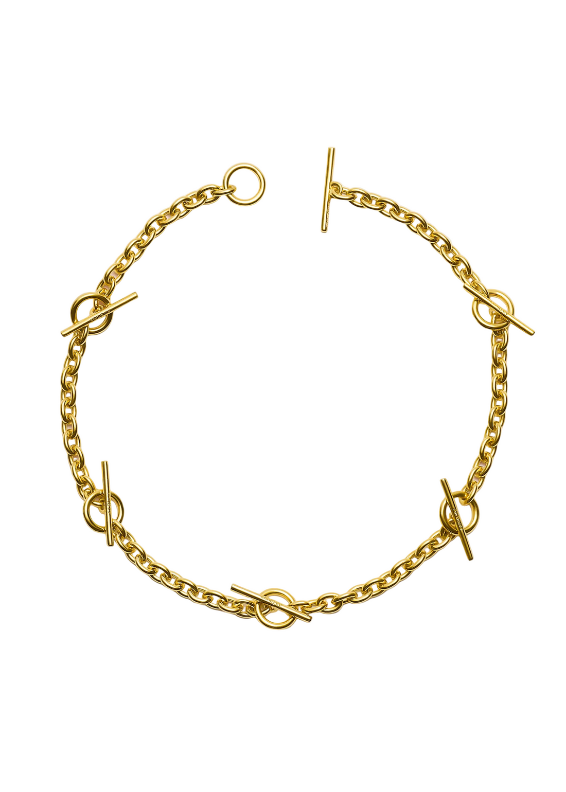 A gold chain bracelet with circular links and toggle clasp closures, photographed flat on a light gray background.