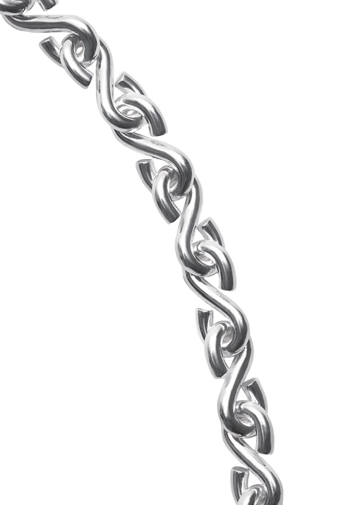 A close-up of a polished silver chain with interlocking oval links, photographed diagonally against a clean, light gray background.
