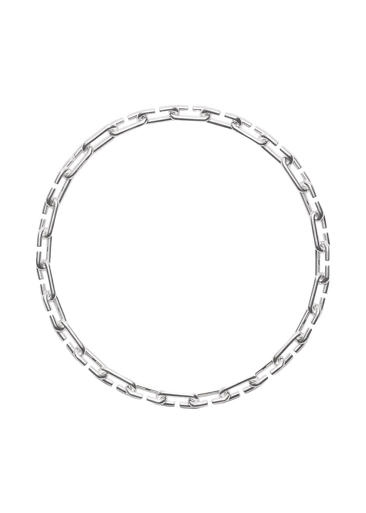 A silver-toned metal link chain necklace arranged in a loose circle on a plain light gray background.
