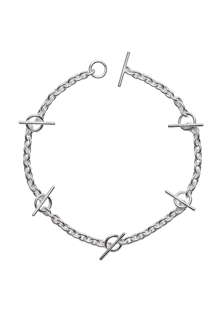 A silver-toned chain bracelet with circular ring details and toggle bar accents, arranged in a circular pattern on a light gray background.